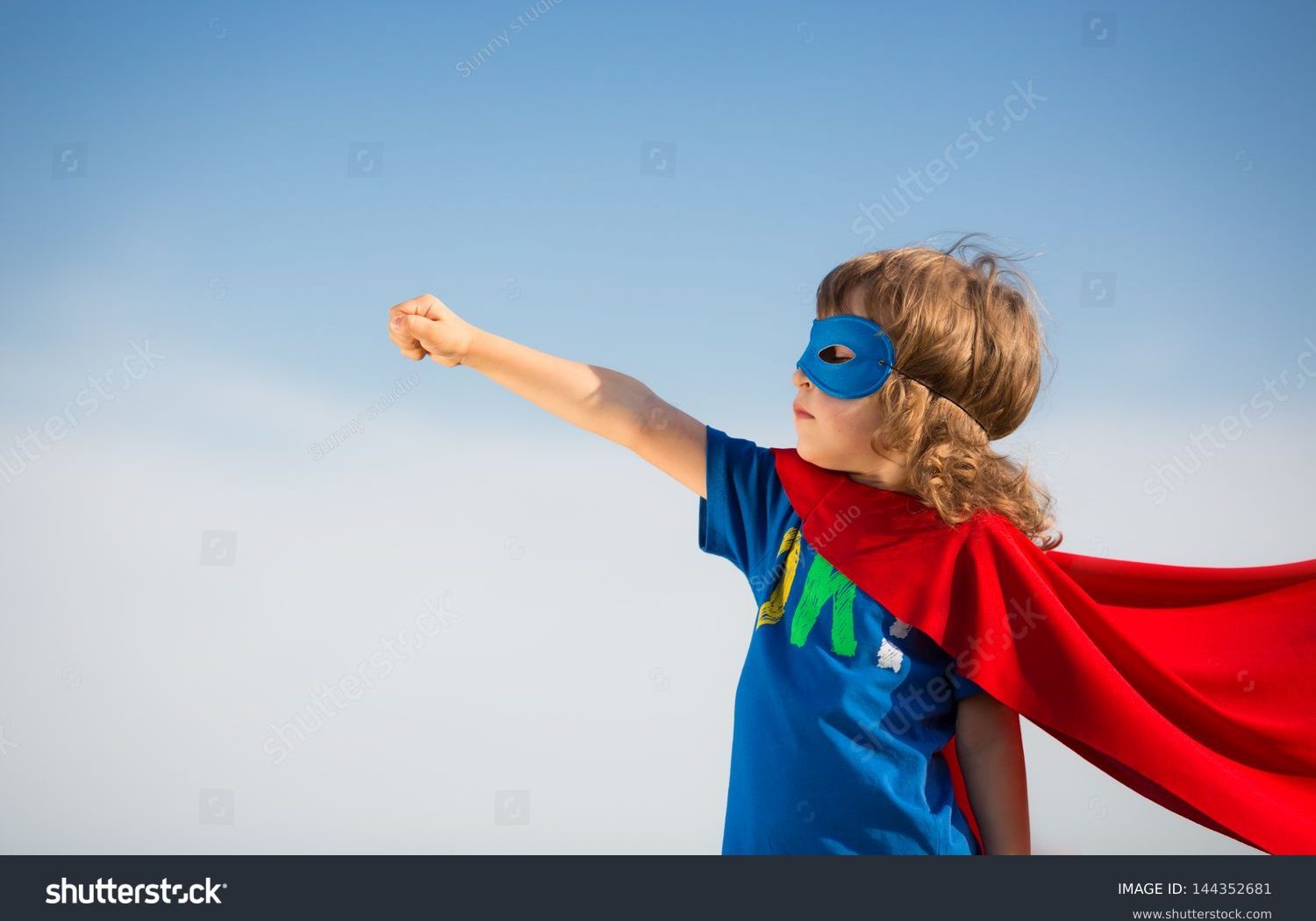 stock-photo-superhero-kid-against-blue-sky-background-girl-power-concept-144352681